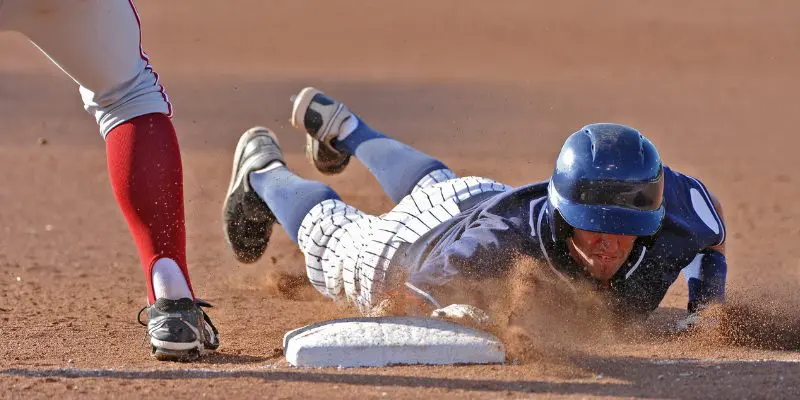 A baseball player attempts to get to base