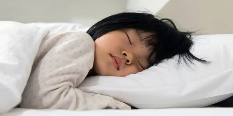 A child sleeps peacefully in bed