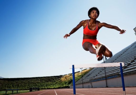 Hurdler jumps over barrier