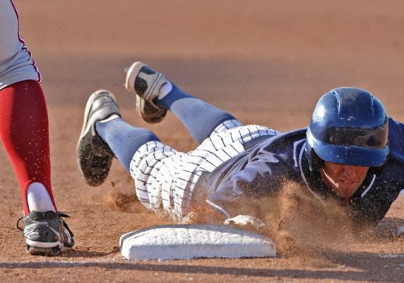 A baseball player attempts to get to base