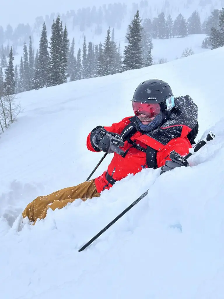 Ken Thompson sitting down on a ski hill in heavy powder