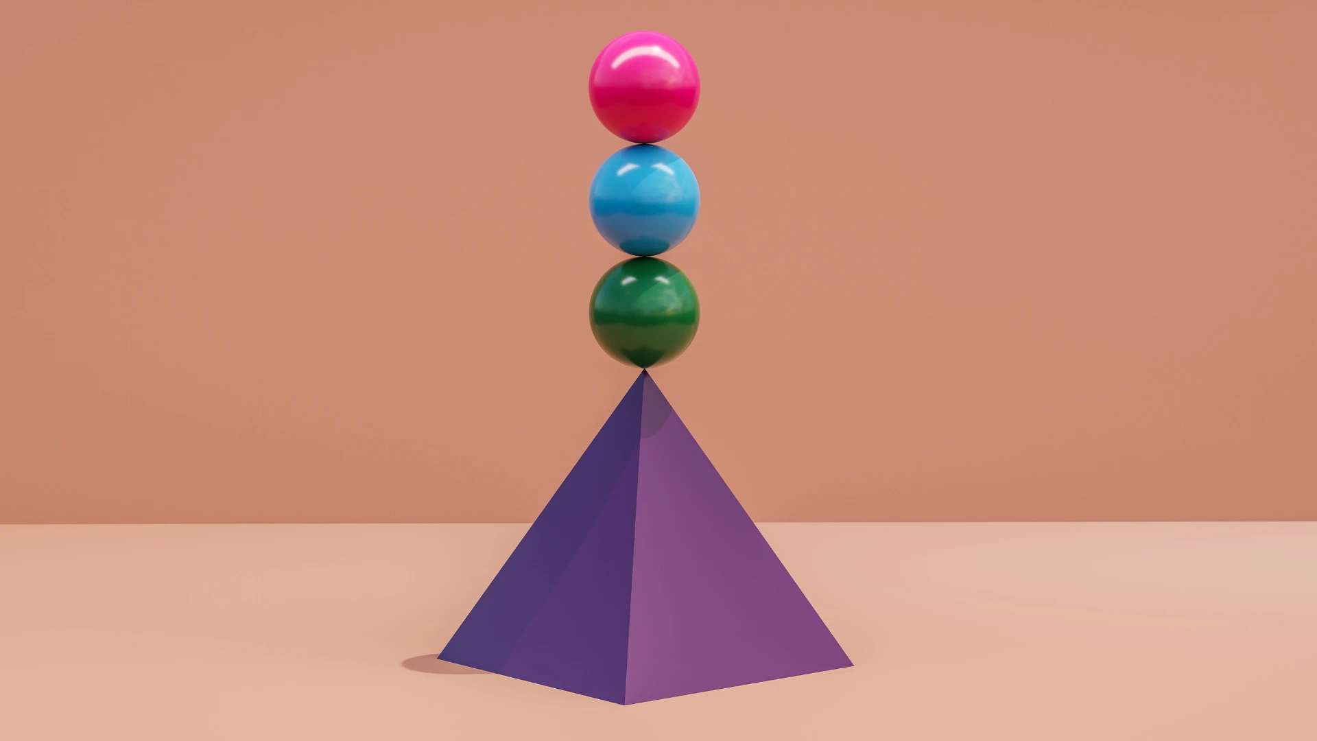Three colorful balls balance on top of a pyramid.