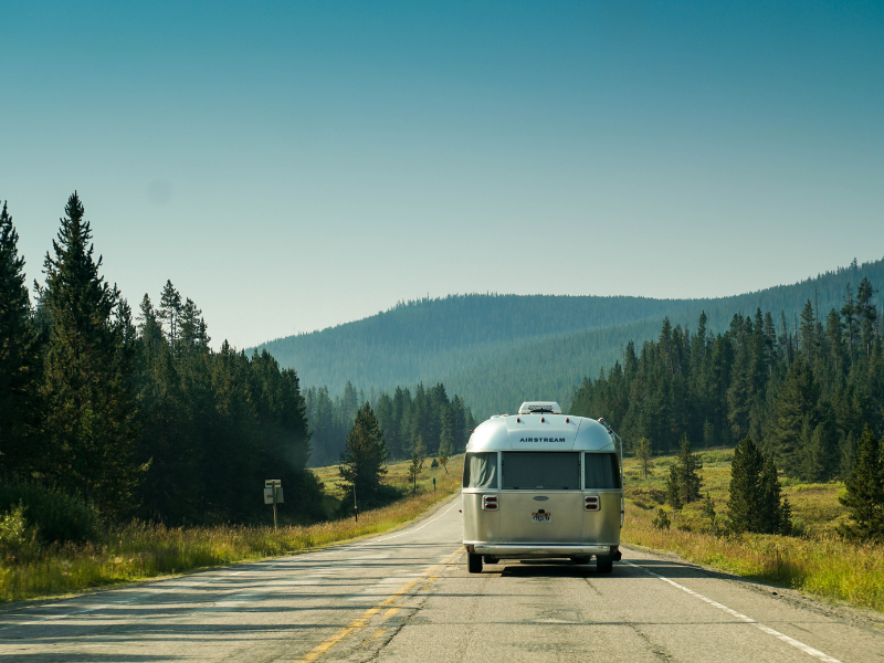 Airstream trailer driving down a mountain road